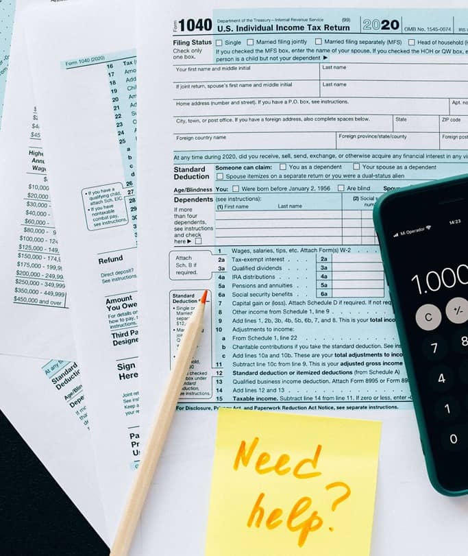 stack of tax documents with a "need help?" post-it note 