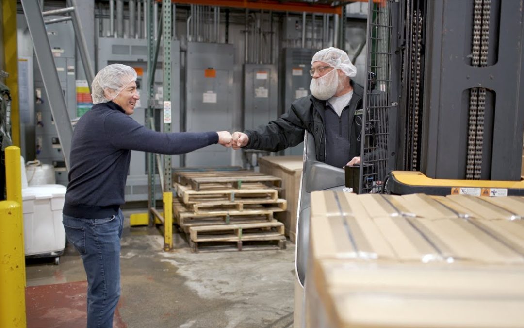 two men shaking hands in a factory